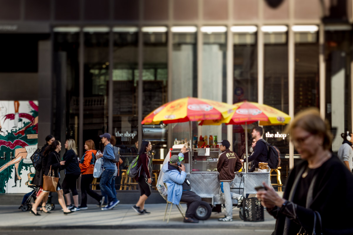 New Yorkers commuting past a food cart