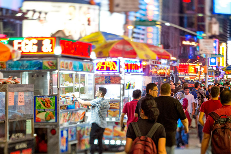A man gets street food in New York City.